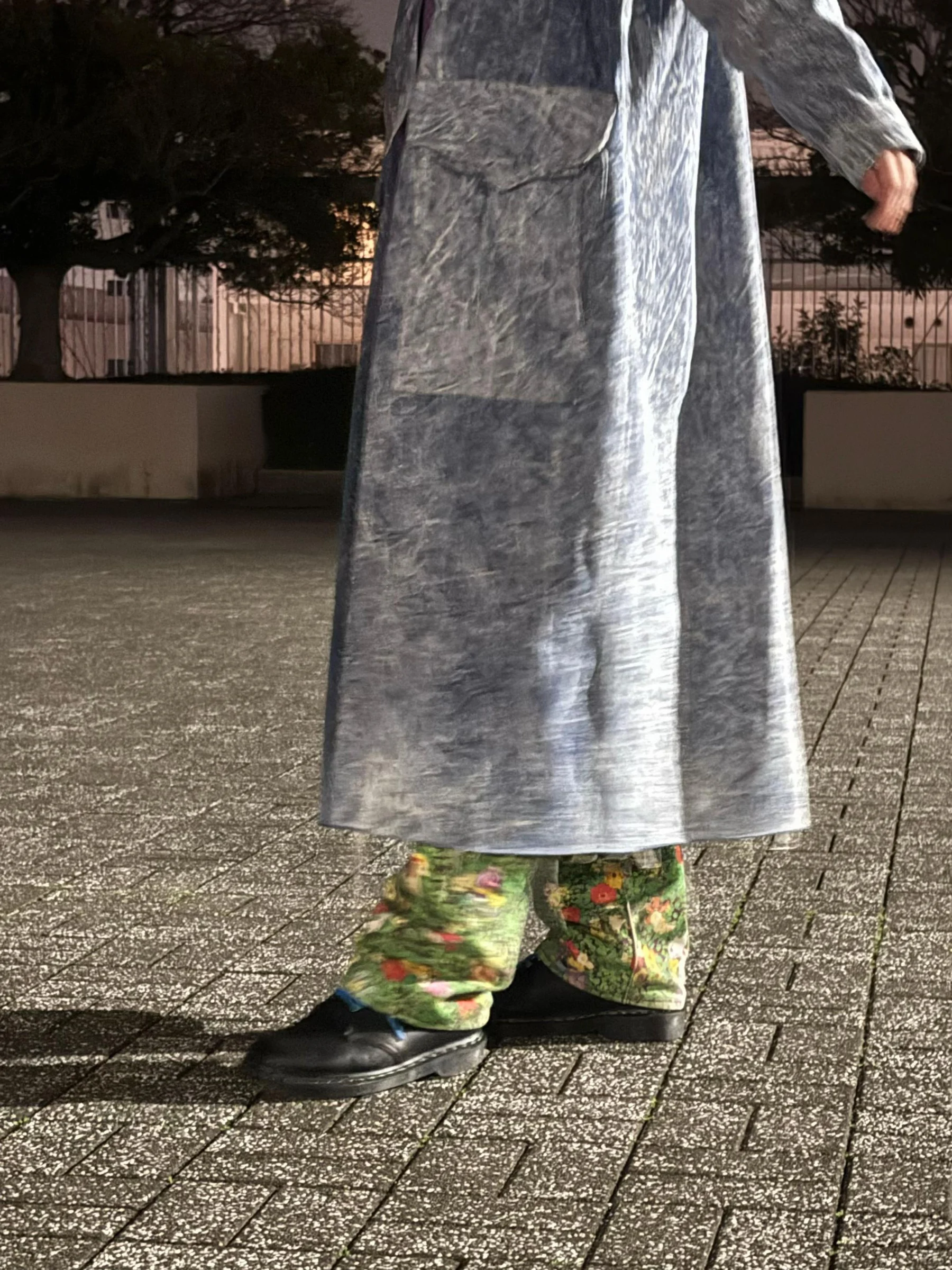 ロングデニムの裾、ポケモン柄の緑のパンツ、黒い靴を写した足元の写真