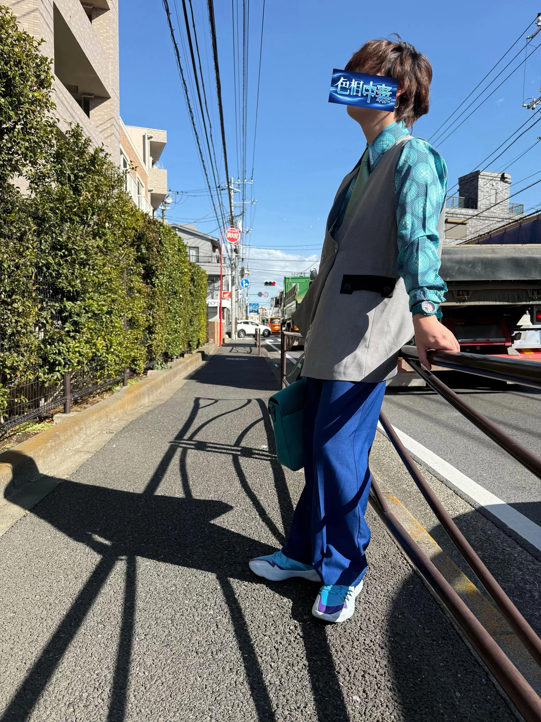 青緑の柄シャツと鮮やかな青いパンツを着た全身のコーディネート