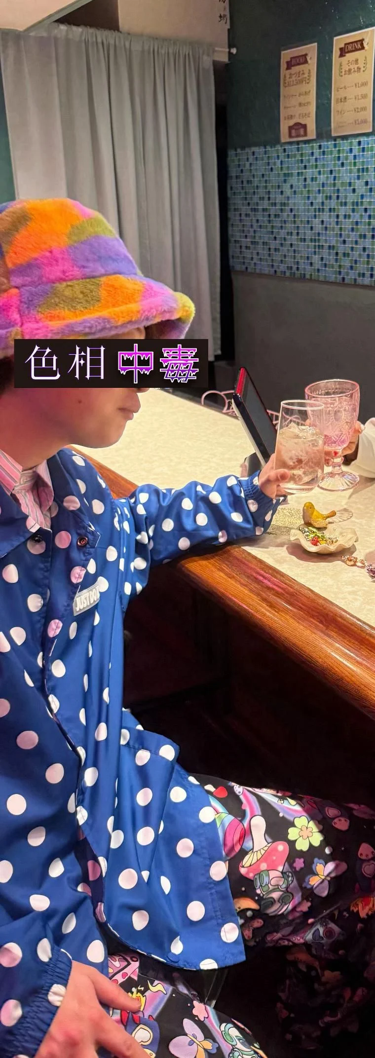 蒔田の店内で青地の白い水玉ジャケットと、多色の大きな柄パンツを着た色相中毒者を本人だけにトリミングした写真